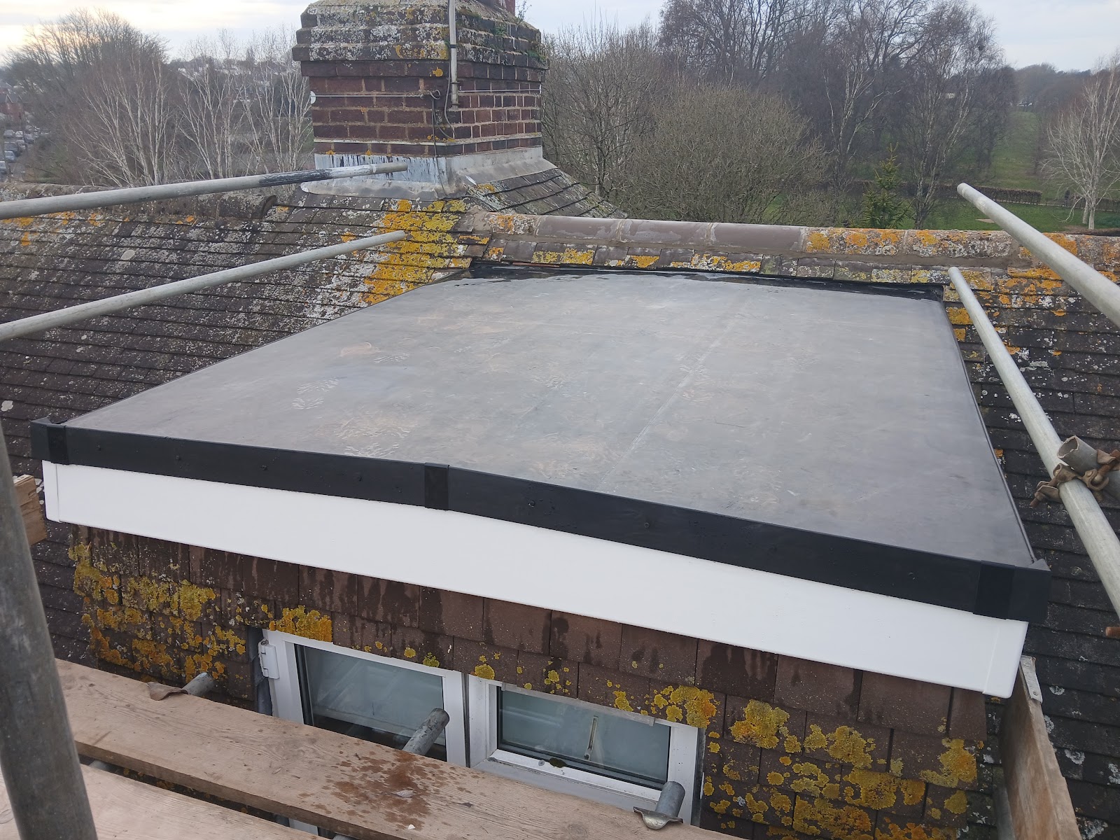 A finished EPDM flat roof with new white fascia boards on a home overlooking Exeter